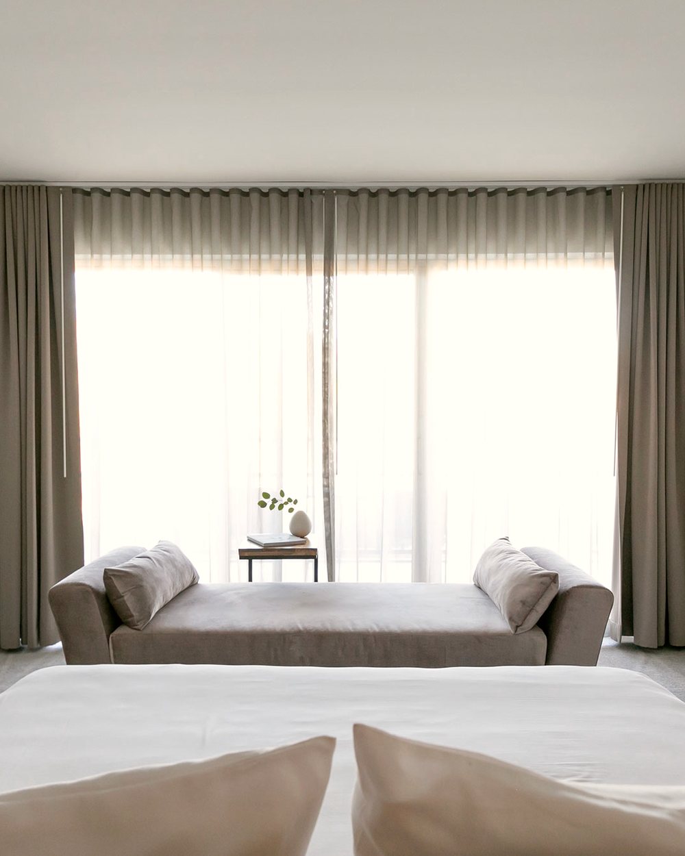 A guest room at CIVANA Carefree, pale and minimal, opening onto the desert